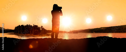 Fotograf im Gegenlicht als Silhouette beim Fotografieren von einem Landschaft...