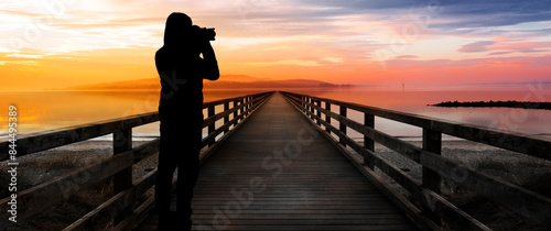 Fotograf im Gegenlicht als Silhouette beim Fotografieren von einem Landschaft...