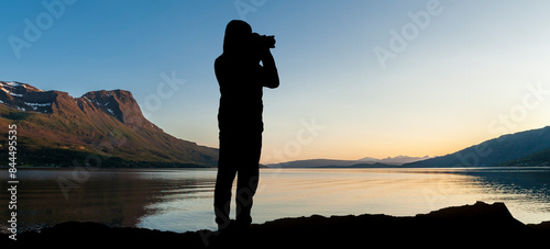 Fotograf im Gegenlicht als Silhouette beim Fotografieren von einem Landschaft...