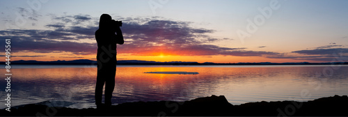 Fotograf im Gegenlicht als Silhouette beim Fotografieren von einem Landschaft...