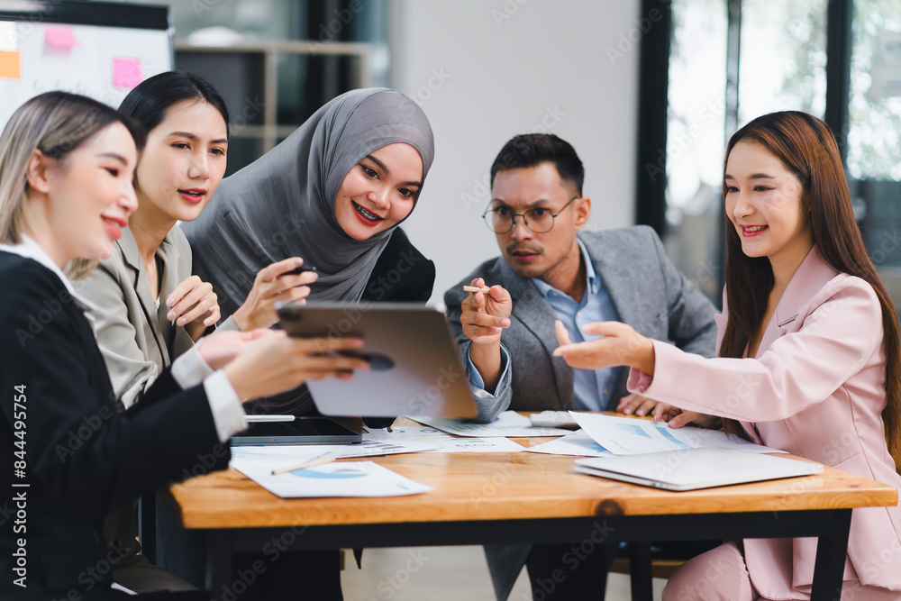 Diverse business team actively collaborating and discussing ideas while using a tablet during an office meeting. Diverse business team actively collaborating and discussing ideas while using a tablet during an office meeting.