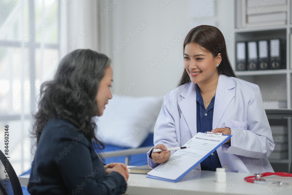 A doctor discussing a patient's health report during a consultation in a modern clinic. A doctor discussing a patient's health report during a consultation in a modern clinic.