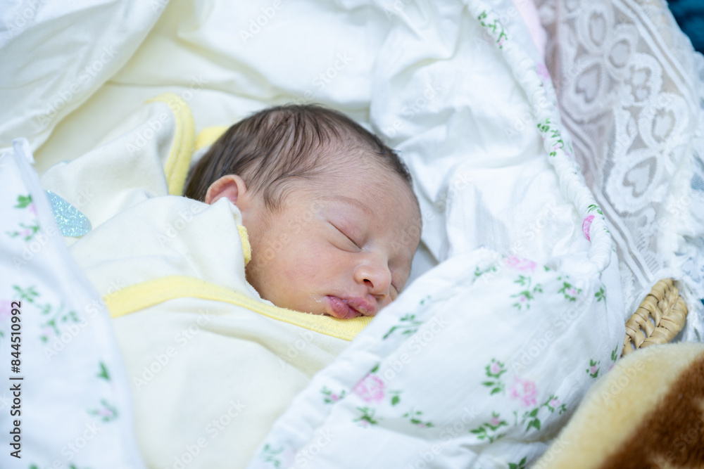 On her first day of life, a newborn baby girl wears a pink hospital ID bracelet on her hand On her first day of life, a newborn baby girl wears a pink hospital ID bracelet on her hand