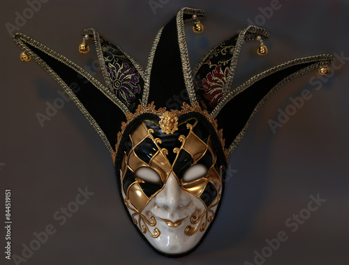 Fotografie A scary jester full face mask isolated on a dark background