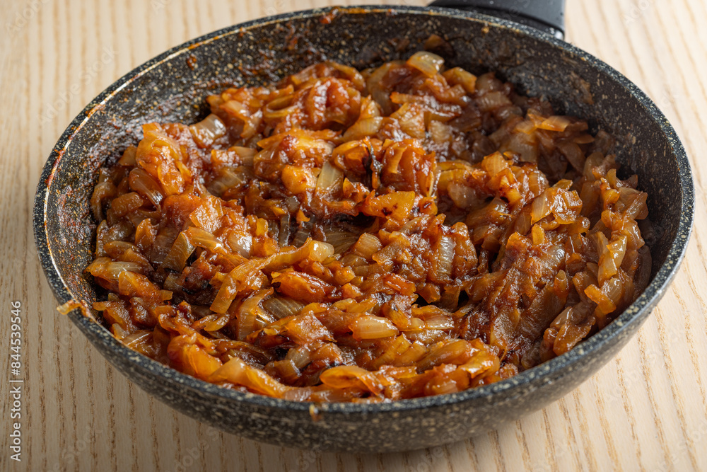 Skillet with fired onion in tomato sauce Skillet with fired onion in tomato sauce
