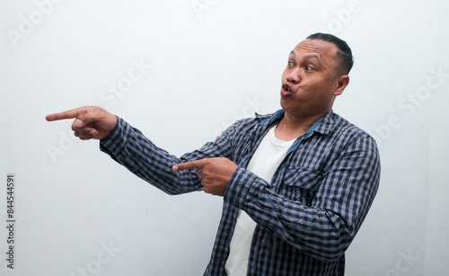 Adult Asian man shocked gesture with his right hand pointing to the side photo