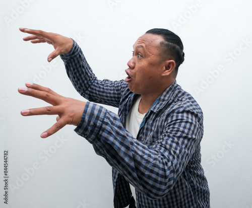 Closeup portrait of adult Asian man showing funny ugly face photo