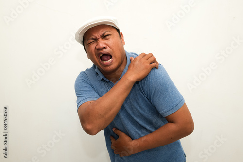 portrait of a asian man with pain in his shoulder photo