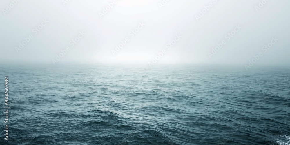 Obraz premium A tranquil view of a calm sea gently merging with a foggy sky, creating a soothing and peaceful atmosphere ideal for reflection and relaxation.