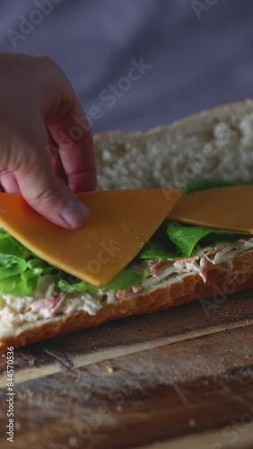 putting cheese on a sandwich