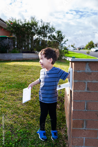 Young Aussie mixed race kid opening mailbox to collect mail