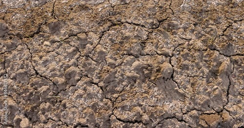 frozen plowed soil in the field in cracks, cracks and fractures on the frozen soil of the field in winter