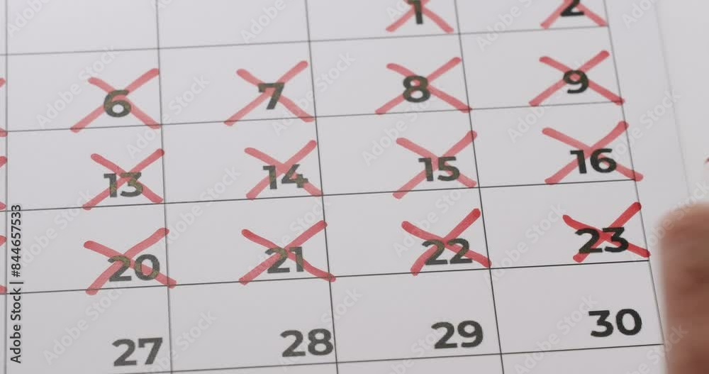Close-up of calendar with red crosses marking passed days, representing schedule tracking and planning. Close-up of calendar with red crosses marking passed days, representing schedule tracking and planning.