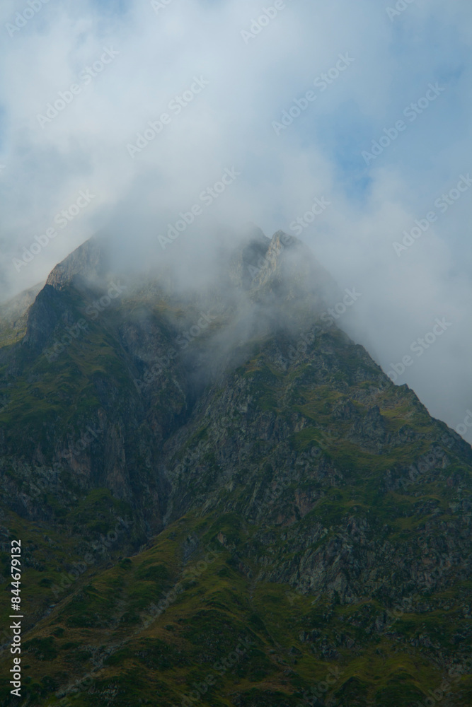 sharp mountain peaks surrounded by wisps of cloud on the summits