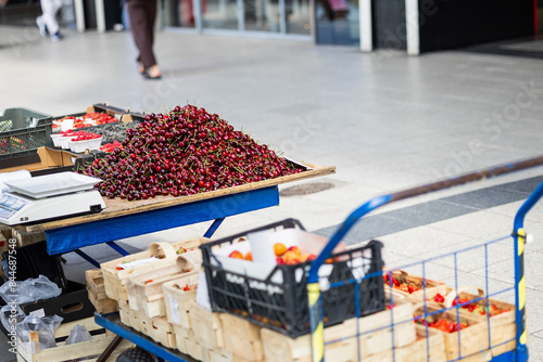 Cherries and strawberries. People are selling and buying fruits on the street in Poland on a sunny day. Visible prices photo