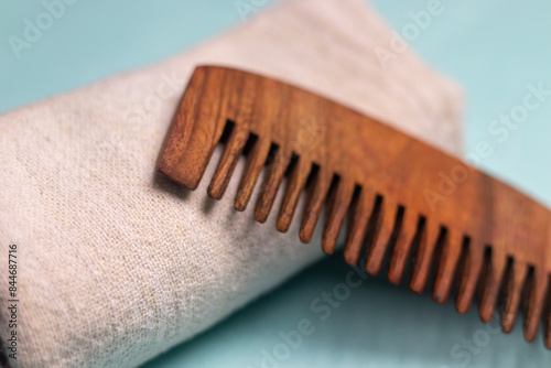 Foto Extreme close-up of a Wooden comb and a properly folded towel kept on a sky blue