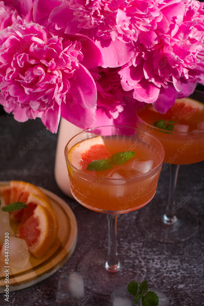 Grapefruit drink in a glass with a straw, mint and ice. Refreshing drink, freshly squeezed refreshing juice Grapefruit drink in a glass with a straw, mint and ice. Refreshing drink, freshly squeezed refreshing juice