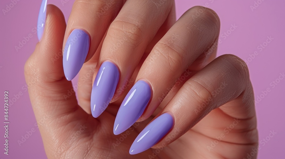 Female hand with extended nails adorned with blue lilac nail polish Female hand with extended nails adorned with blue lilac nail polish