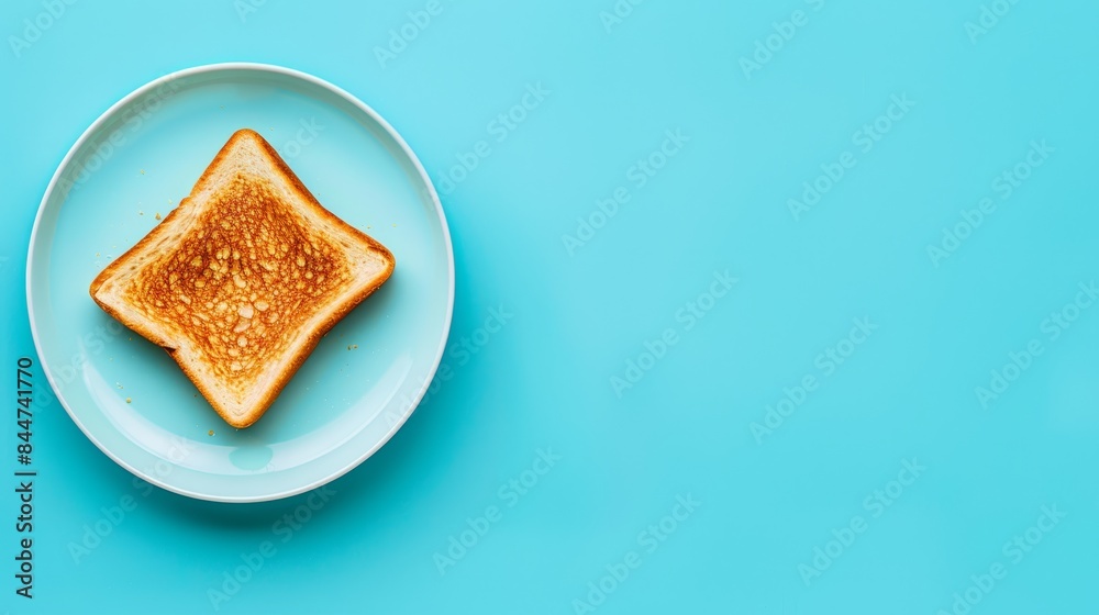 A toast slice on a white plate against a light blue surface, another toast slice halved and placed on its own white plate A toast slice on a white plate against a light blue surface, another toast slice halved and placed on its own white plate