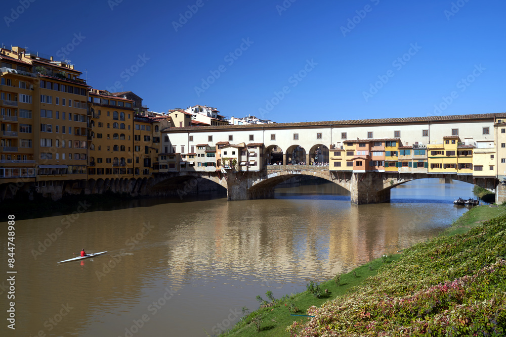 Obraz premium Bridge, tenement houses and historic buildings over the Arno river in the city of Florence