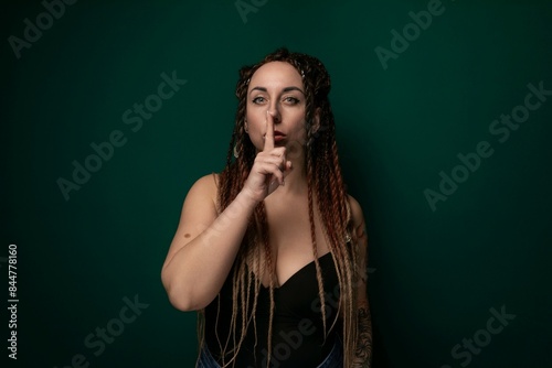 Woman With Dreadlocks Holding Finger to Mouth