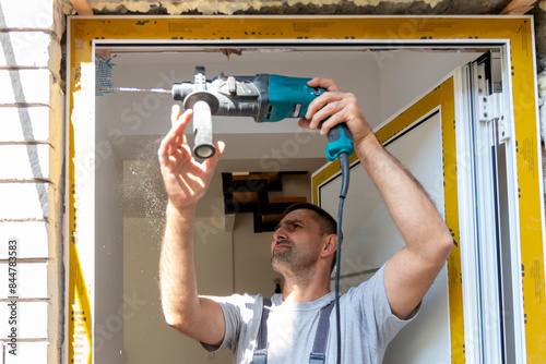 Professional carpenters installing an entrance door in a new apartment. Door installation worker replaced the old one with a new one