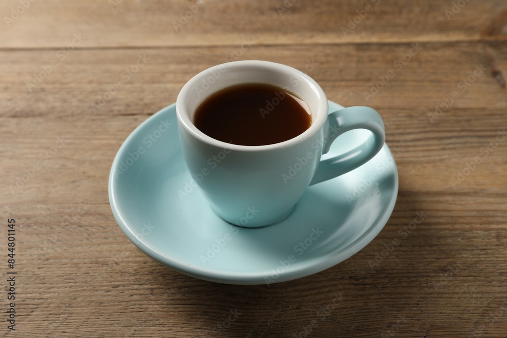 Tasty coffee in cup on wooden table, closeup Tasty coffee in cup on wooden table, closeup