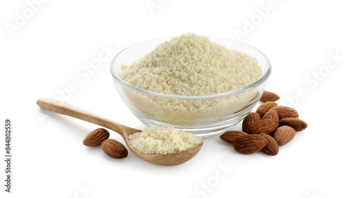 Fresh almond flour in bowl, spoon and nuts isolated on white