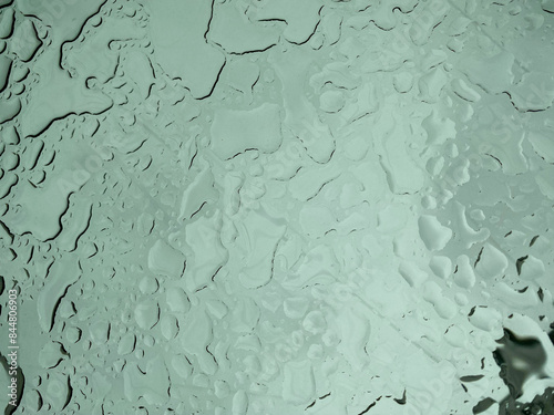 raindrops on the glass through which the cloudy sky is visible