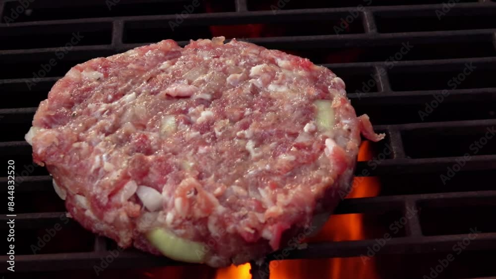 Close-up of the raw homemade burger cutlet made of meat and onions roasting above the open fire outdoors Close-up of the raw homemade burger cutlet made of meat and onions roasting above the open fire outdoors