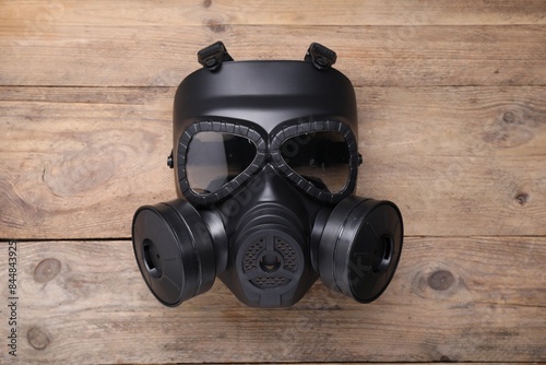 One gas mask on wooden background, top view photo