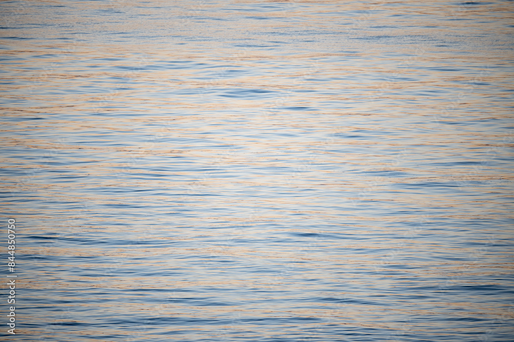 The wavy surface of the sea illuminated by the light of the sunset The wavy surface of the sea illuminated by the light of the sunset
