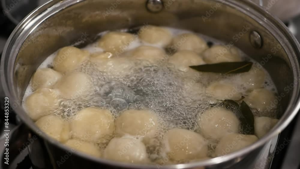Dumplings are cooked in a pan. Boiling dumplings in a pan. Cooking food in the kitchen in slow motion Dumplings are cooked in a pan. Boiling dumplings in a pan. Cooking food in the kitchen in slow motion
