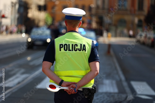 Policjant drogówki z lizakiem do zatrzymywania pojazdów kontroluje ruch drogowy. Tarcza.  photo