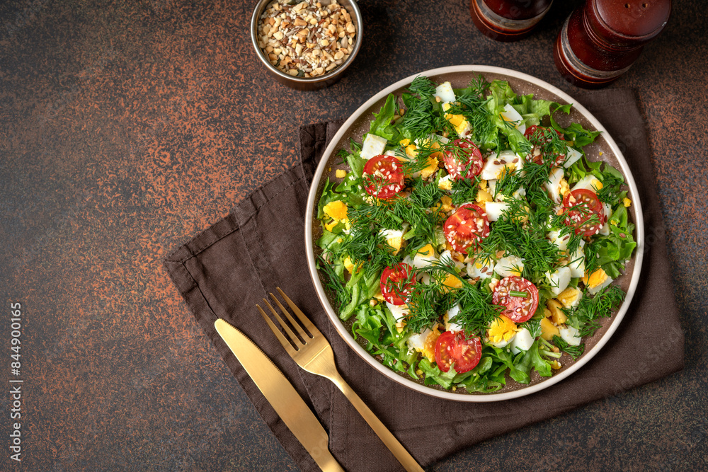 Salad with eggs, cherry tomatoes, dill, lettuce leaves and olive oil. Food for weight loss. Top view from the copyspace