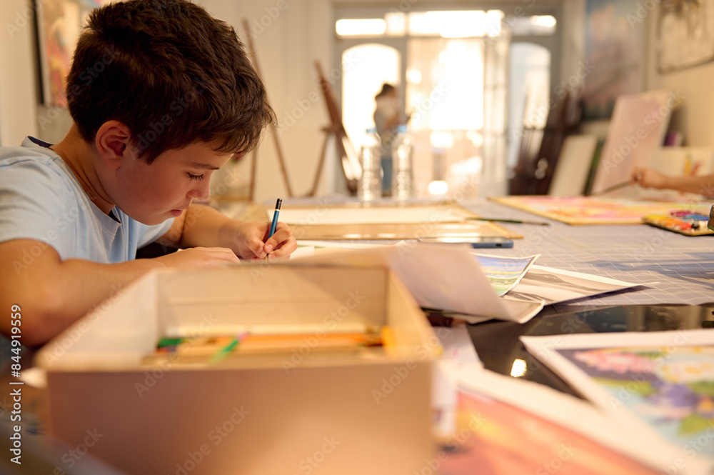 Focused child drawing during art class session in a creative workshop Focused child drawing during art class session in a creative workshop