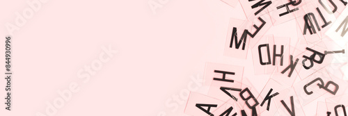 Banner with transparent plastic cards with letters scattered on a pink background. Place for text. photo