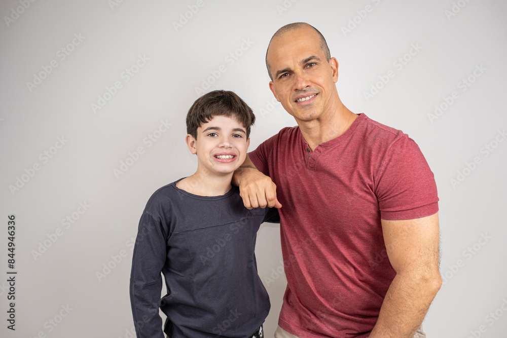Father and son hugging and smiling looking at the camera. Photos in studio_1. Father and son hugging and smiling looking at the camera. Photos in studio_1.