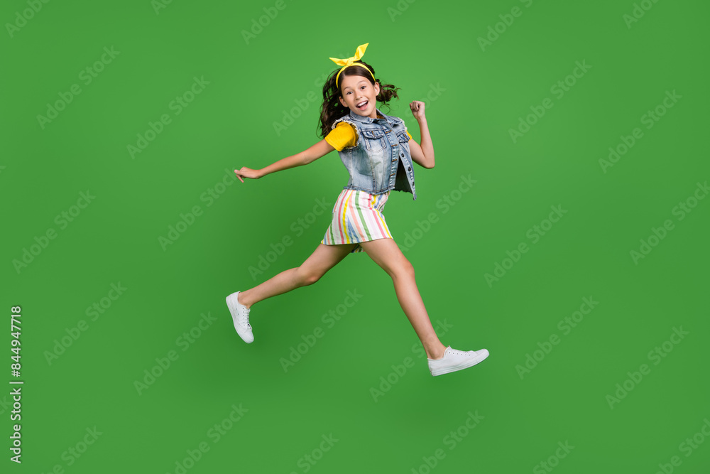 Photo of positive girl kid jump run isolated green color background