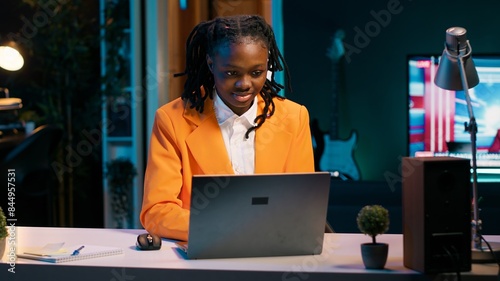 Canvas Print Dedicated woman diligently typing on laptop in the comfort of her home office, writing school essay to finish university homework