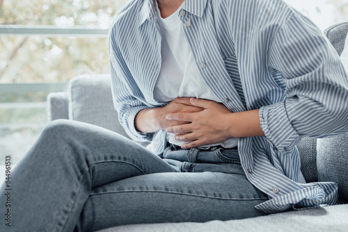 Foto Sick young woman in pain holding belly stomach feeling hurt abdomen ache gastritis pancreatitis symptoms or diarrhea, upset teen girl suffering from indigestion flatulence abdominal problem concept
