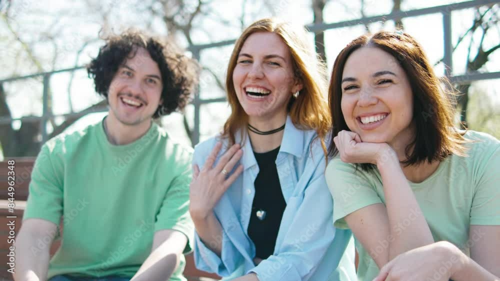 Group of friends laughing and enjoying each others company outdoors on a sunny day at the park