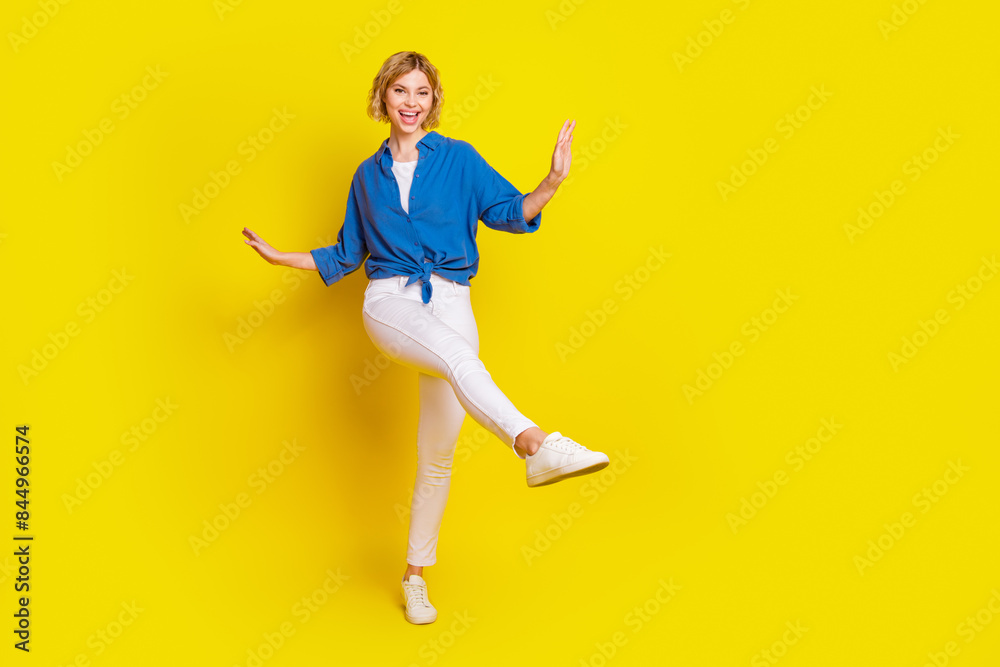 Full body portrait of pretty young lady dancing wear shirt isolated on yellow color background Full body portrait of pretty young lady dancing wear shirt isolated on yellow color background
