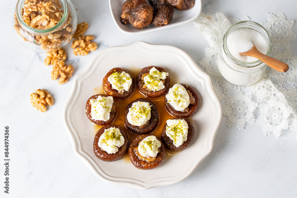 Stuffed dry fig dessert, cooked with syrup, traditional, pistachio and kaymak (Turkish name; kaymakli incir tatlisi )