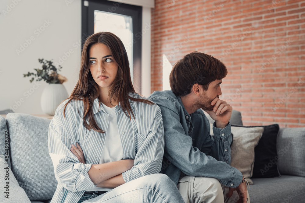 Beautiful lady is depressed, sitting on the couch talking to man, having a dispute with husband or boyfriend, looking desperate and hopeless, having unresolved problem or question. Beautiful lady is depressed, sitting on the couch talking to man, having a dispute with husband or boyfriend, looking desperate and hopeless, having unresolved problem or question.