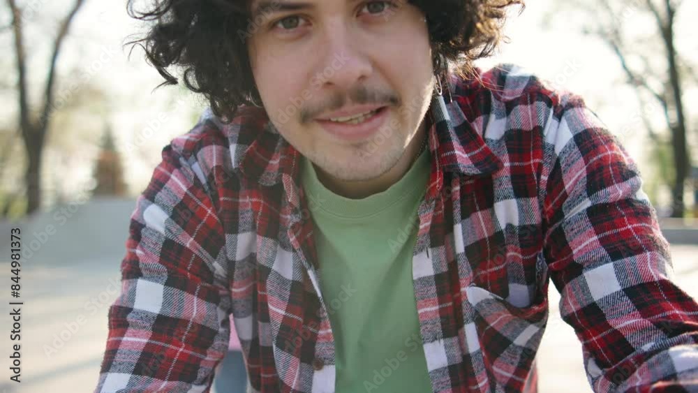 happy brunette curly man in red checkered shirt sets up video camera for making vlog with girlfriend happy brunette curly man in red checkered shirt sets up video camera for making vlog with girlfriend