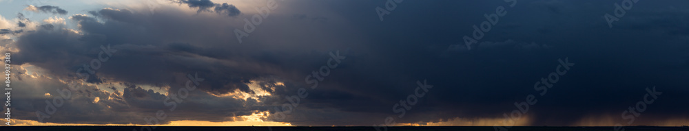 Landscape at sunset. A thunderstorm is approaching the village. Tragic gloomy sky. Panorama. Landscape at sunset. A thunderstorm is approaching the village. Tragic gloomy sky. Panorama.