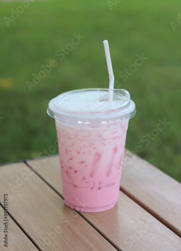 Pink iced milk in a plastic cup