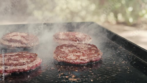 Hamburgers grilling on flat top outside in summer
