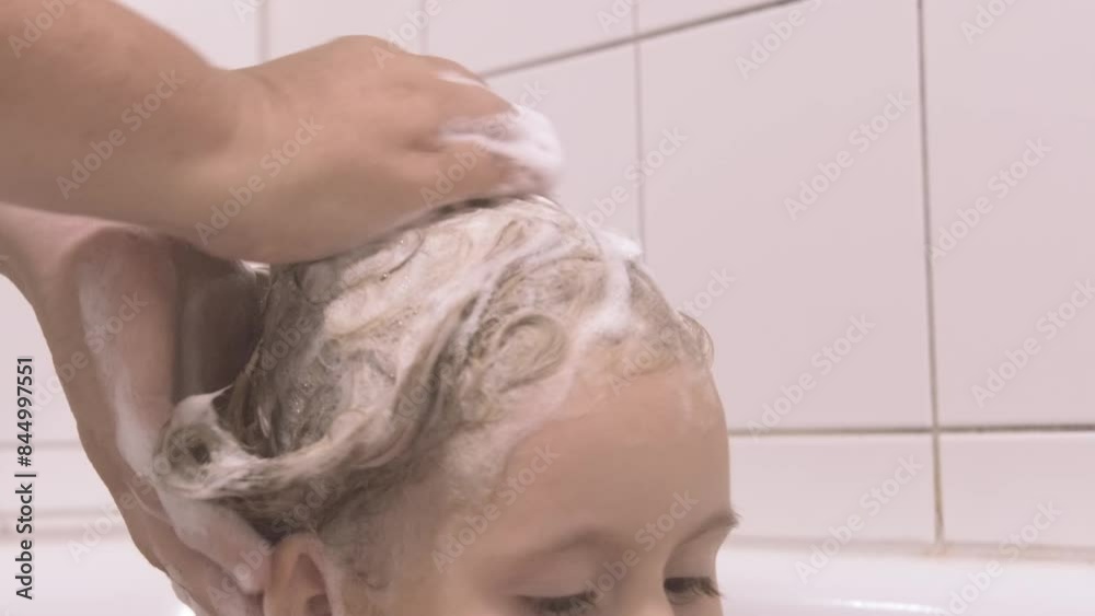 mother's hands gently wash young daughter's hair, soap suds on head, tender connection between a mother and child, act hygiene becomes bonding moment mother's hands gently wash young daughter's hair, soap suds on head, tender connection between a mother and child, act hygiene becomes bonding moment